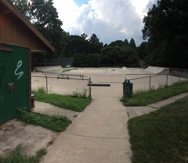 skatepark surrounded by wire fence and a hut nearby