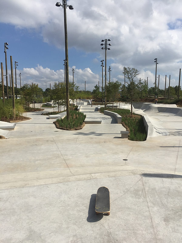 ledges and pyramids in a skatepark with skateboard in the foreground