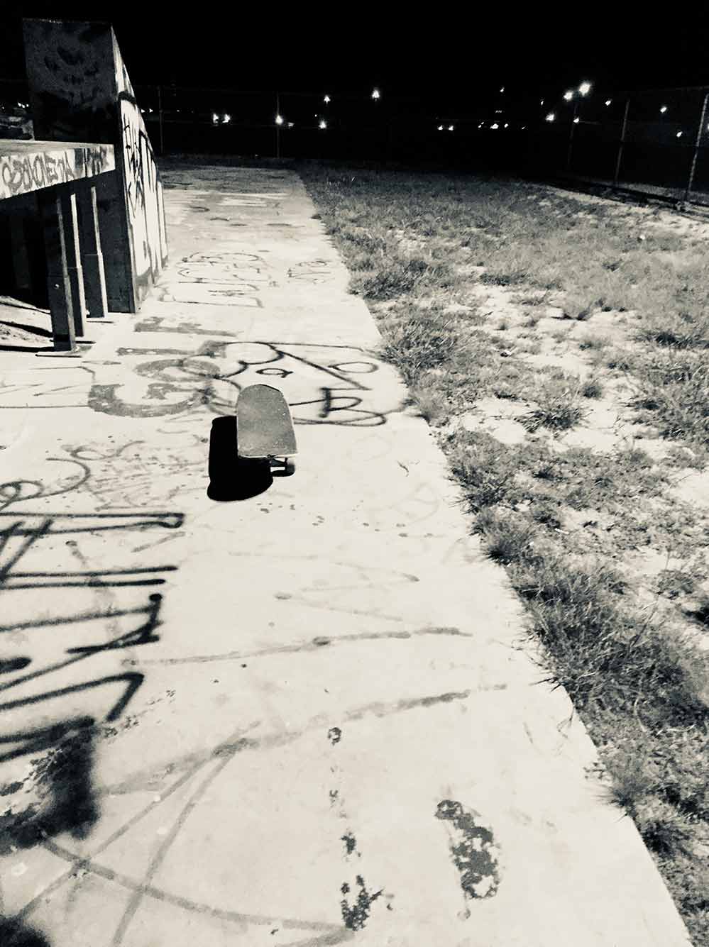 Isolated skatepark in the dark illuminated by streetlights