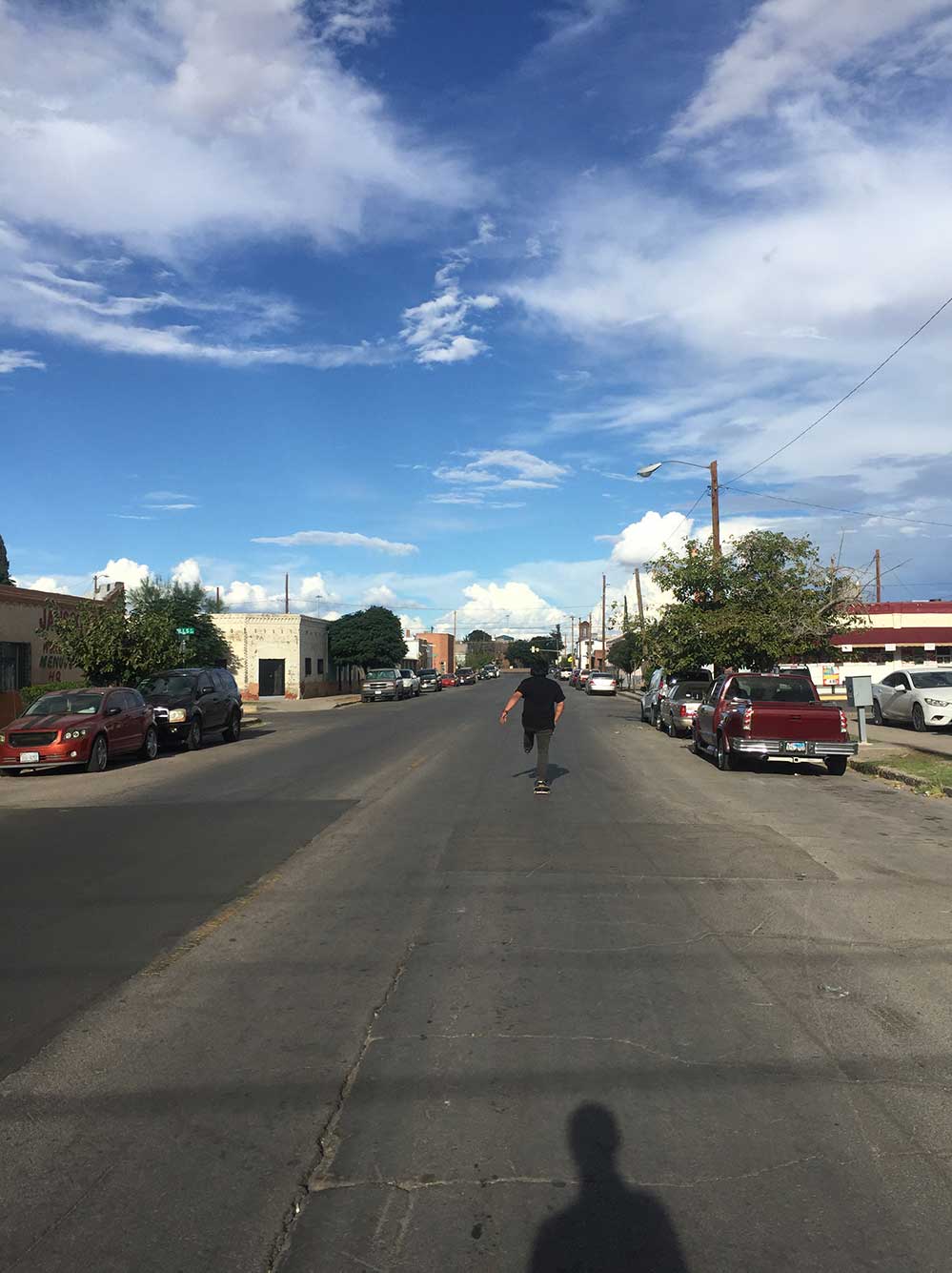 Boy on skateboard up ahead on road